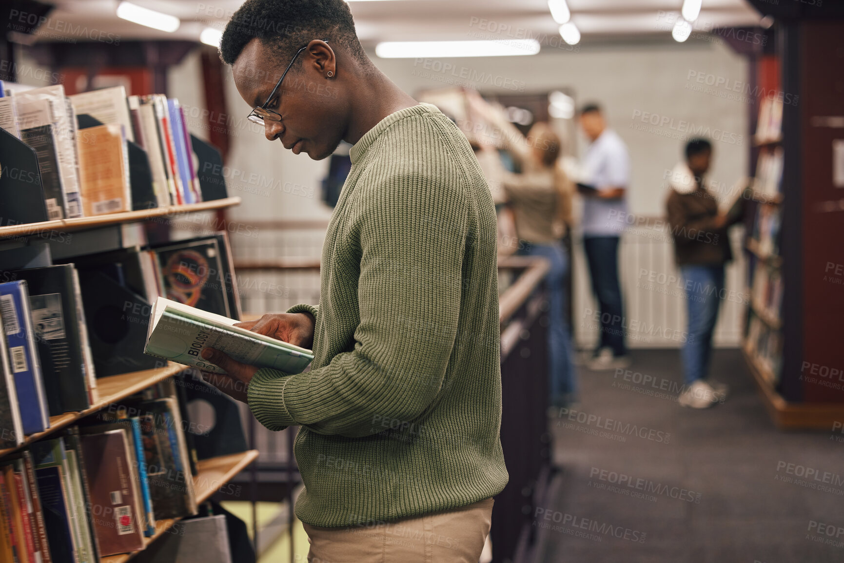 Buy stock photo Black man student, reading and library with book, research and education at college to ready for exam. African gen z man, books and shelf at university for study, learning and motivation in Boston