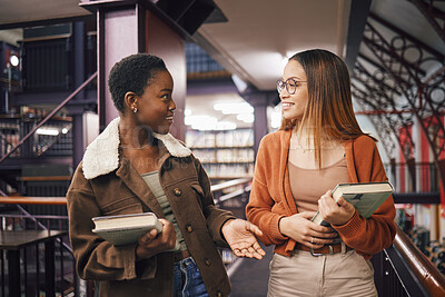Buy stock photo University students, library and talking about books, education and learning together at campus. Women friends have conversation about knowledge, studying and walking to research studying scholarship