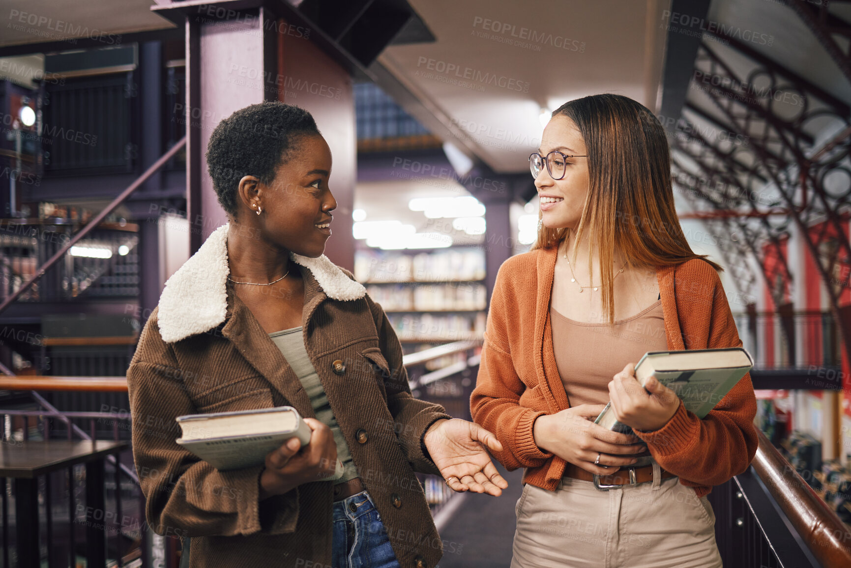 Buy stock photo University students, library and talking about books, education and learning together at campus. Women friends have conversation about knowledge, studying and walking to research studying scholarship