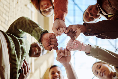 Buy stock photo Below, students and fist hands in group for support, motivation or education in sunshine at college. Diversity, fist bump and community with teamwork, studying or scholarship at university for future