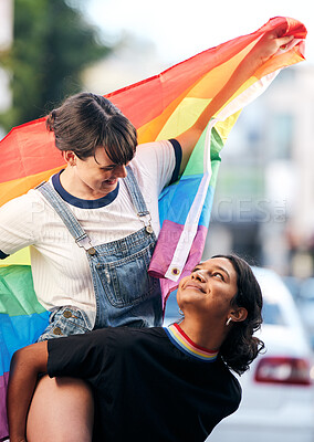 Buy stock photo Women, lgbtq couple and piggyback with flag for pride, love and support in city street. Diversity, lesbian and gay friends celebrate rainbow identity, freedom and happiness of human rights together