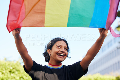 Buy stock photo Rainbow, flag and lgbt with an indian woman in the city in celebration of human rights, equality or freedom. Community, support and gay with a gender neutral or non binary female celebrating lgbtq