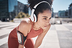 Phone, fitness app and headphones, tired black woman runner stop to relax or breathe on city workout run. Health, urban training and wellness, woman on break from running exercise and streaming music