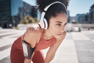 Buy stock photo Phone, fitness app and headphones, tired black woman runner stop to relax or breathe on city workout run. Health, urban training and wellness, woman on break from running exercise and streaming music