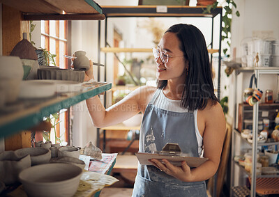 Buy stock photo Pottery, woman or small business owner with inventory, stock and product quality, management and production results. Art startup checklist, creative worker and asian designer check design on a shelf