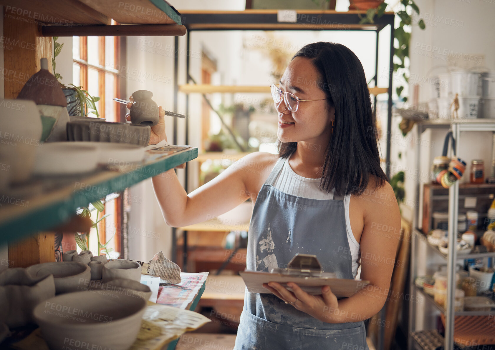 Buy stock photo Pottery, woman or small business owner with inventory, stock and product quality, management and production results. Art startup checklist, creative worker and asian designer check design on a shelf