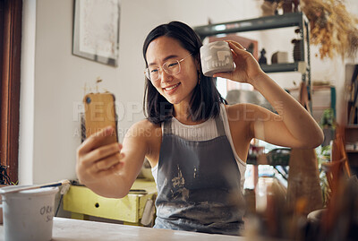 Buy stock photo Artist woman, pottery and selfie with smile, design and product in studio to sell on internet, app or social media. Asian art girl, sculpture and smartphone with happiness, vision and artwork at desk