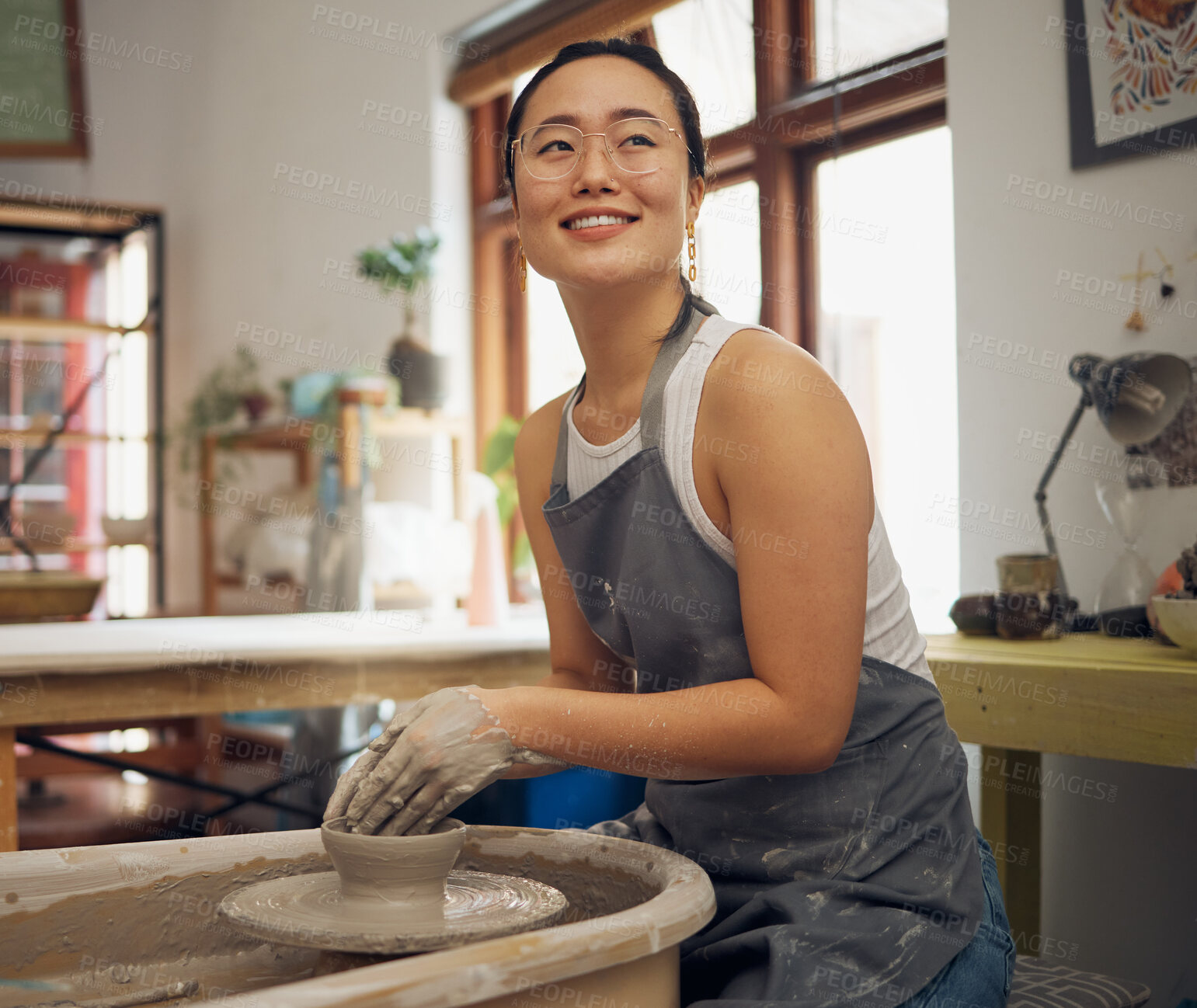 Buy stock photo Pottery, thinking and creative with an asian woman using a wheel for the design of an art of ceramic product. Artistic, idea and inspiration with a female potter working in her studio or workshop