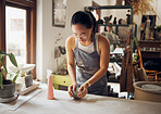 Idea, design and pottery business woman with clay for creativity, inspiration and art process in workshop. Creative asian small business girl working at artistic workspace in Tokyo, Japan

