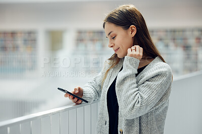 Buy stock photo Woman, phone and smile for social media, networking or chatting in communication at a library. Happy female smiling for texting, research or browsing for books on smartphone at big book store or mall