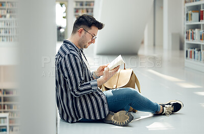 Buy stock photo Man, student and reading in library with book for knowledge, education or learning at the university. Male learner in study with books for thesis, project or assignment for scholarship at the campus