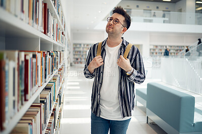 Buy stock photo Library bookshelf, student and search for university, college or school books for research, learning and knowledge. Study, reading print and geek man with backpack for history, language or philosophy