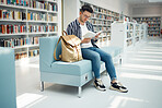 Library, reading and man with book on sofa for education, studying and academic research. University, scholarship and male student on couch for learning, hobby and knowledge in college bookstore