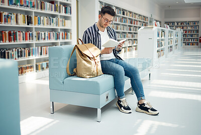 Buy stock photo Library, reading and man with book on sofa for education, studying and academic research. University, scholarship and male student on couch for learning, hobby and knowledge in college bookstore