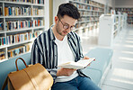 Education, man and student reading in library, knowledge and studying for exams, test and intelligent. Young male, guy and academic with book, learning and university study area, peace and creative