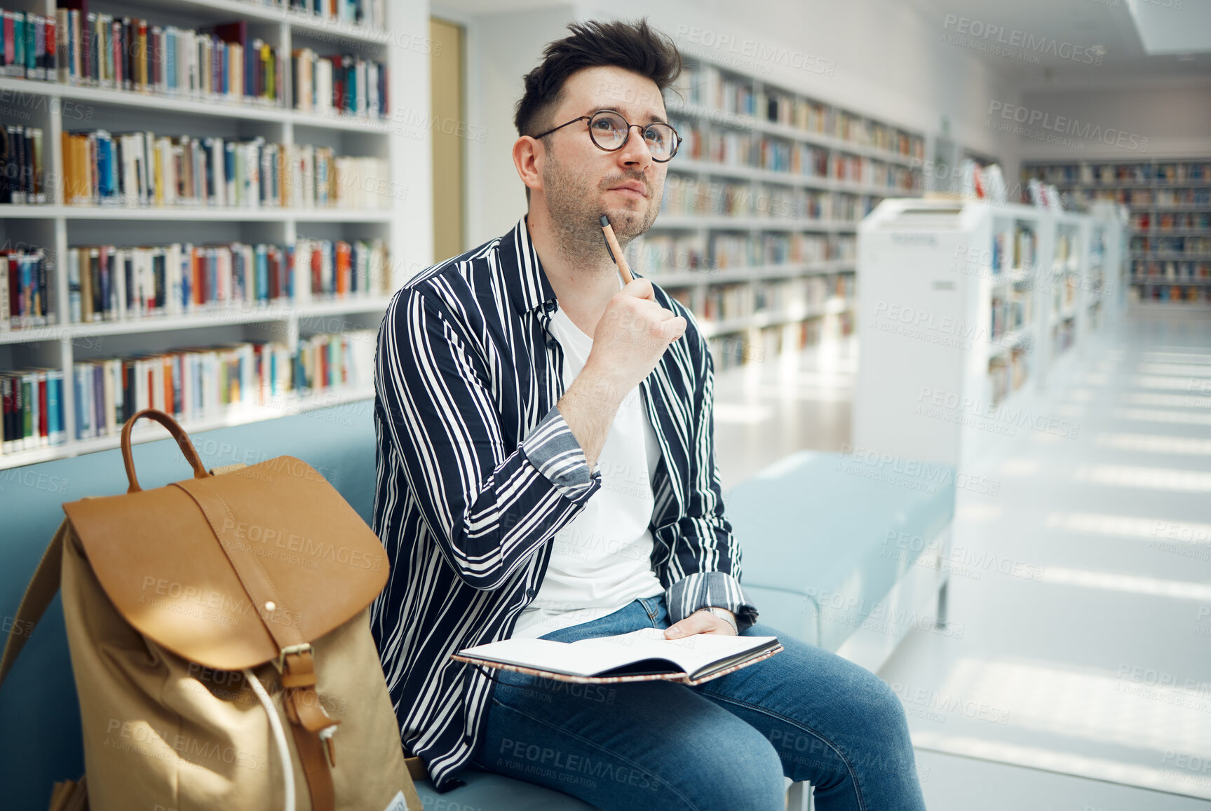 Buy stock photo University, student and thinking of idea in library for educational task with focus and notebook. Learning, knowledge and education of smart college man busy with assignment note ideas.

