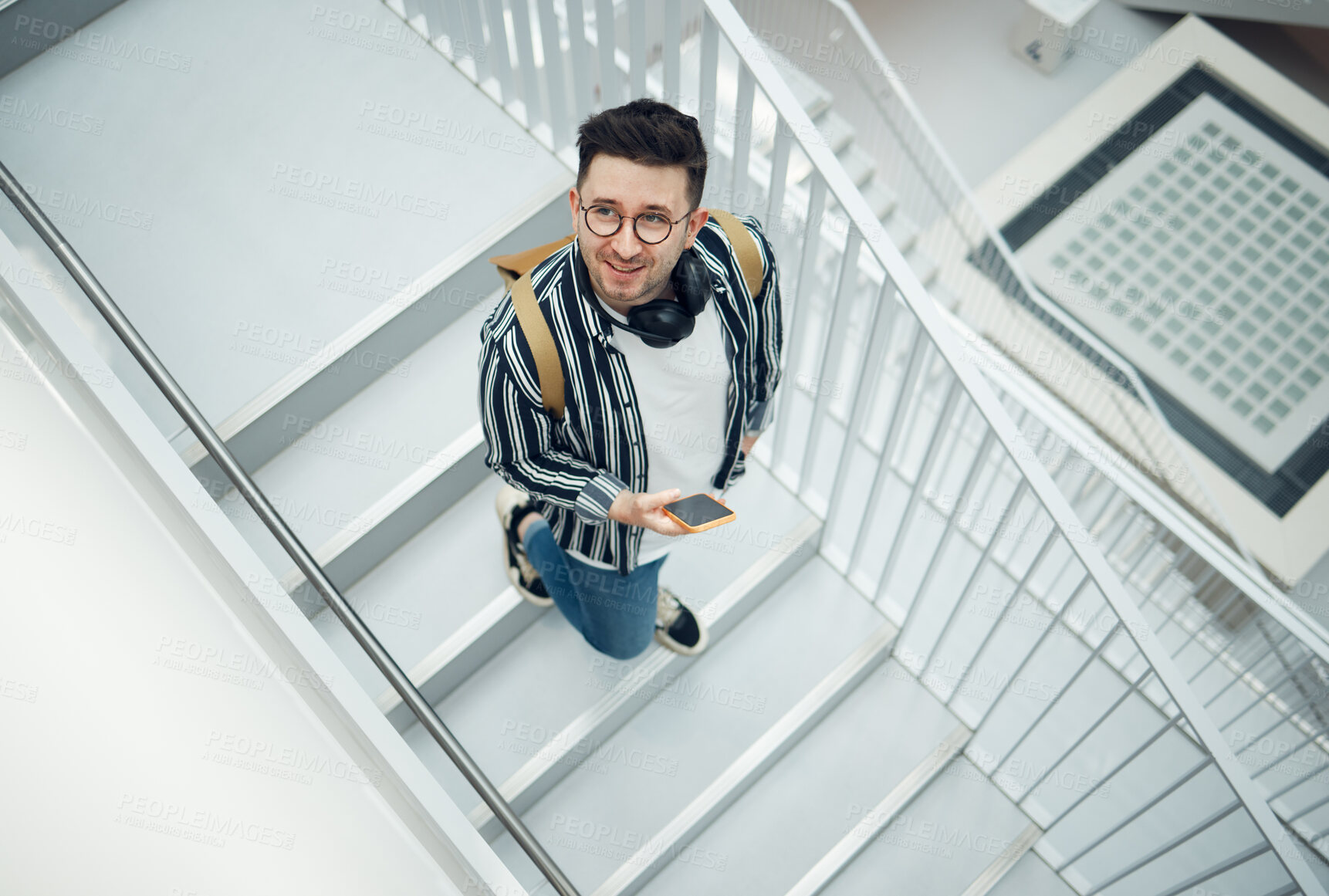 Buy stock photo Happy, student or startup man with phone on staircase for internet research, social media content or networking. Smile, top or employee nerd on smartphone for strategy, blog review or communication