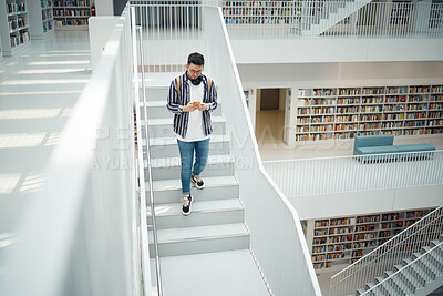 Buy stock photo College student, walking stairs and campus with phone, reading and communication on social media. Man, university student and smartphone app for email in library for education, learning and studying