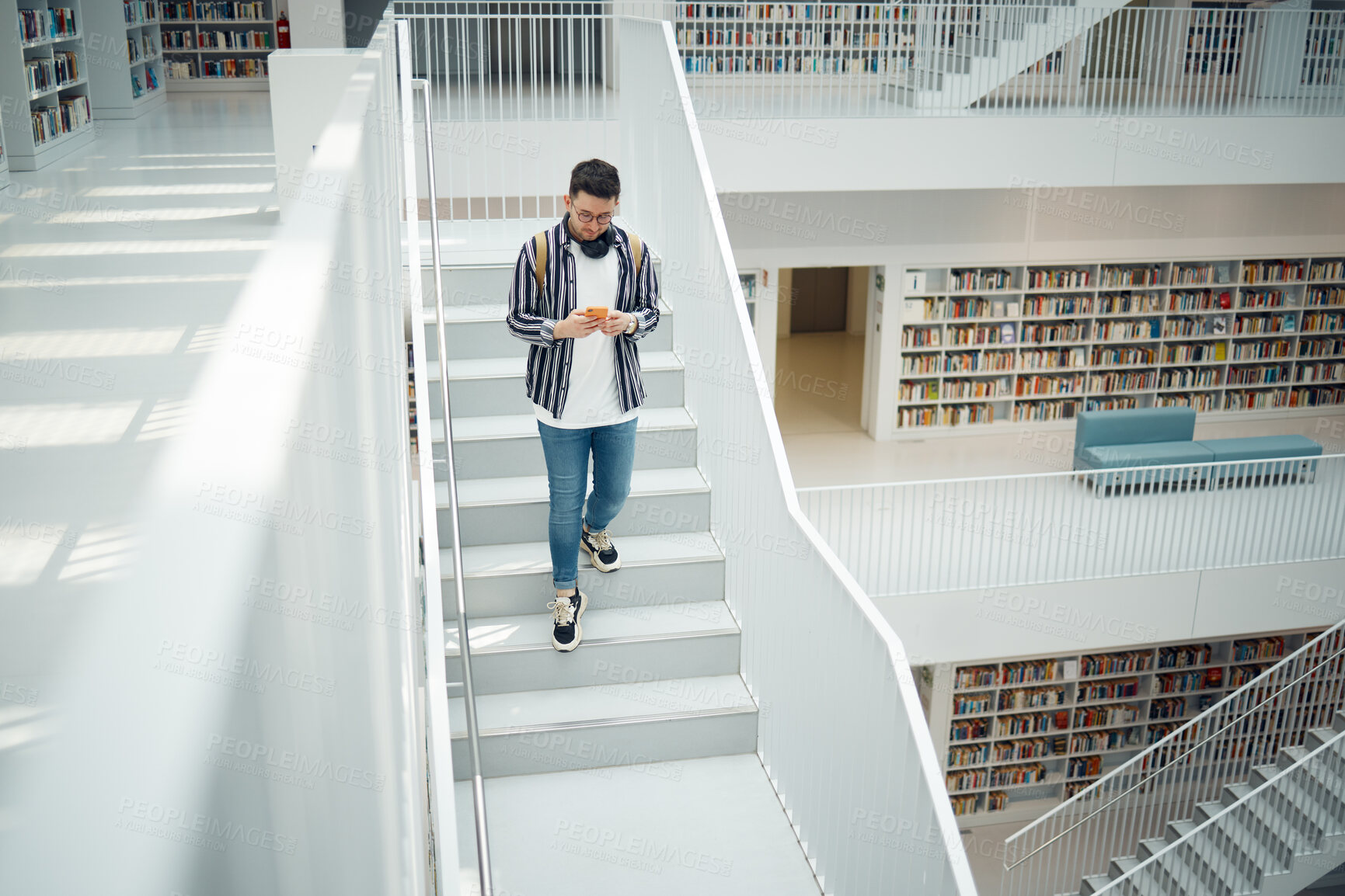 Buy stock photo College student, walking stairs and campus with phone, reading and communication on social media. Man, university student and smartphone app for email in library for education, learning and studying