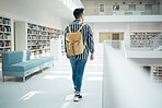 Backpack, library and education with a man student walking in a university bookstore for education or learning. Back, college and research with a male pupil taking a walk in search of a book