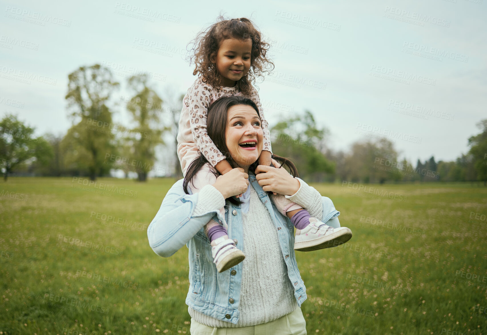 Buy stock photo Mother, girl and sitting on shoulders in park for happiness, bonding or care in nature, walk or together outdoor. Woman, child and game on holiday, love or play for adventure at field in Toronto