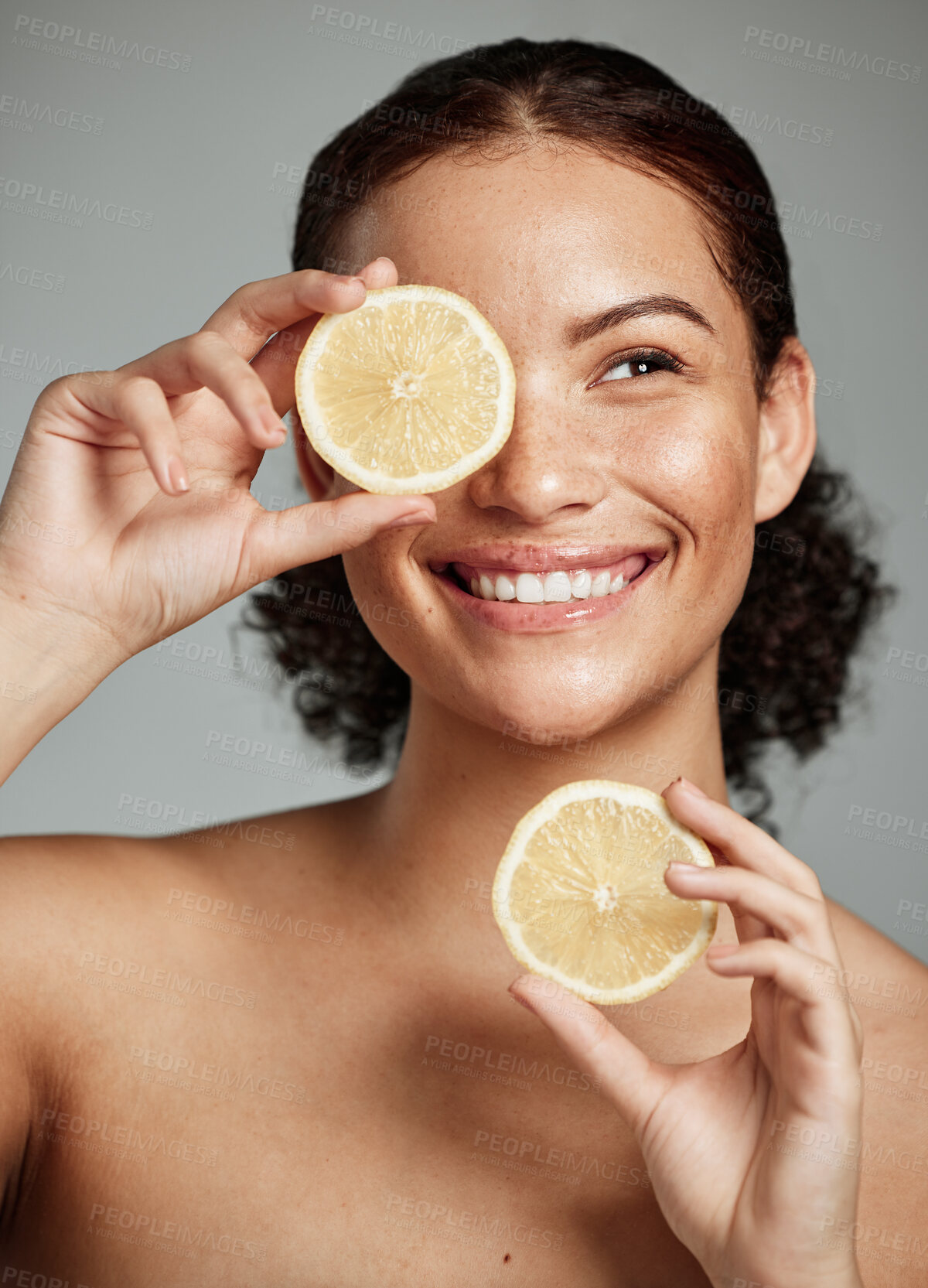 Buy stock photo Face, skincare and woman with lemon in studio isolated on a gray background. Fruit, organic cosmetics and happy female model holding lemons for healthy diet, vitamin c or minerals, wellness or beauty