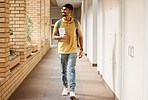 University student, college and indian man walking with a smile and backpack down campus corridor. Gen z male happy about education, learning and future after studying with scholarship at school