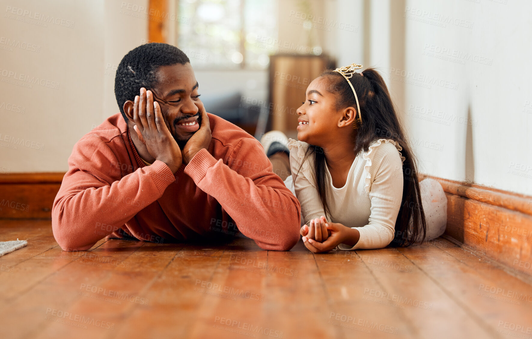 Buy stock photo Father, love and daughter relax on the floor, happy and bonding while talking in their home together. Black family, girl and parent enjoy conversation while lying, content and sweet on the weekend