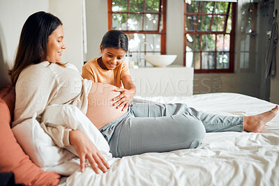 Buy stock photo Relax, pregnant and family woman on bed with excited, happy and joyful smile of curious child. Indian girl with mother and young kid waiting for baby sibling bonding together in home bedroom.