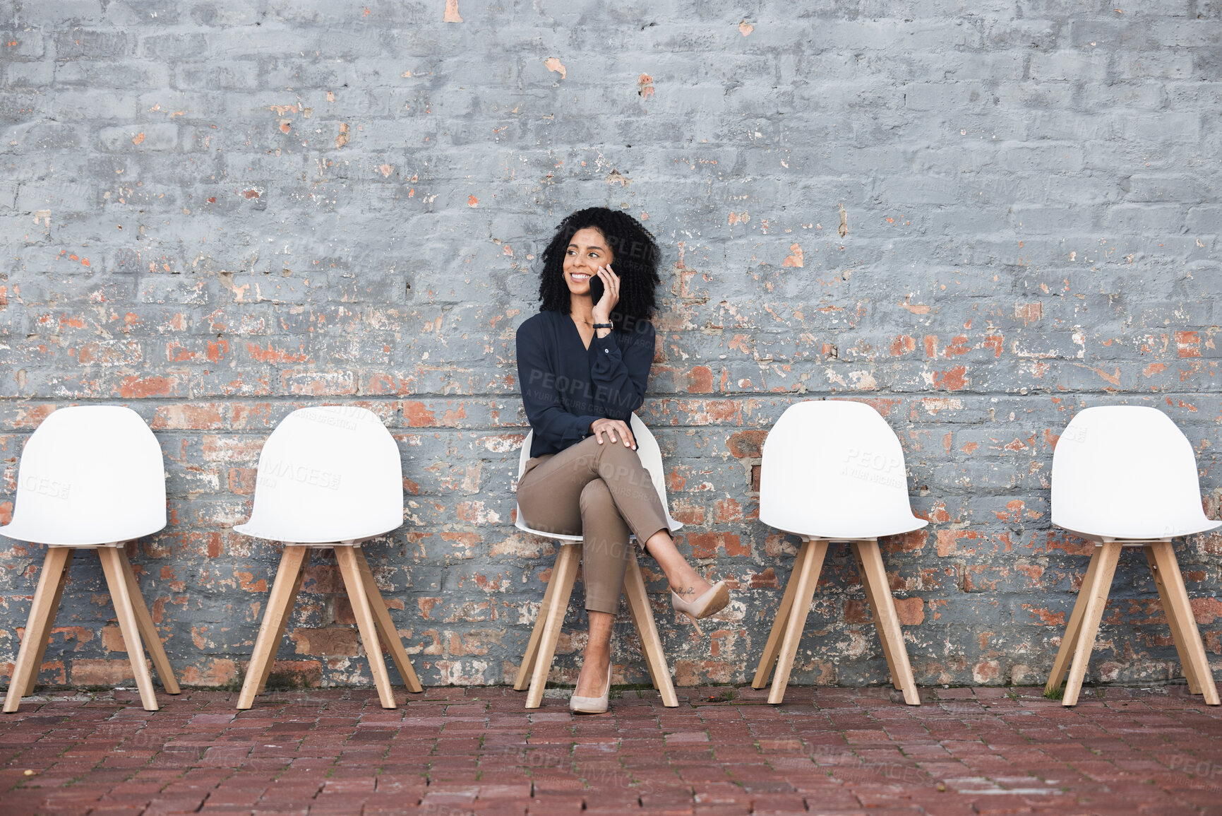 Buy stock photo Phone call, recruitment and black woman on brick wall, sitting in line for hr news, job opportunity and success. Smartphone, waiting room and person mobile chat for career networking and contact us