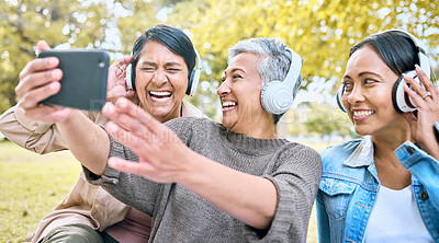 Buy stock photo Senior woman, friends and phone laughing with headphones listening to music or watching comedy movie in the park. Group of happy elderly women enjoying funny series or 5G connection on smartphone
