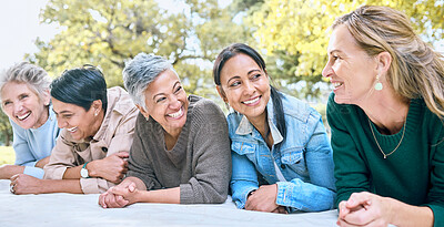 Buy stock photo Happy, women and relax at a park, laughing and bonding while lying on a blanket together. Diversity, friends and woman group bonding, funny and enjoying comic, humor and goofy joke while on a picnic