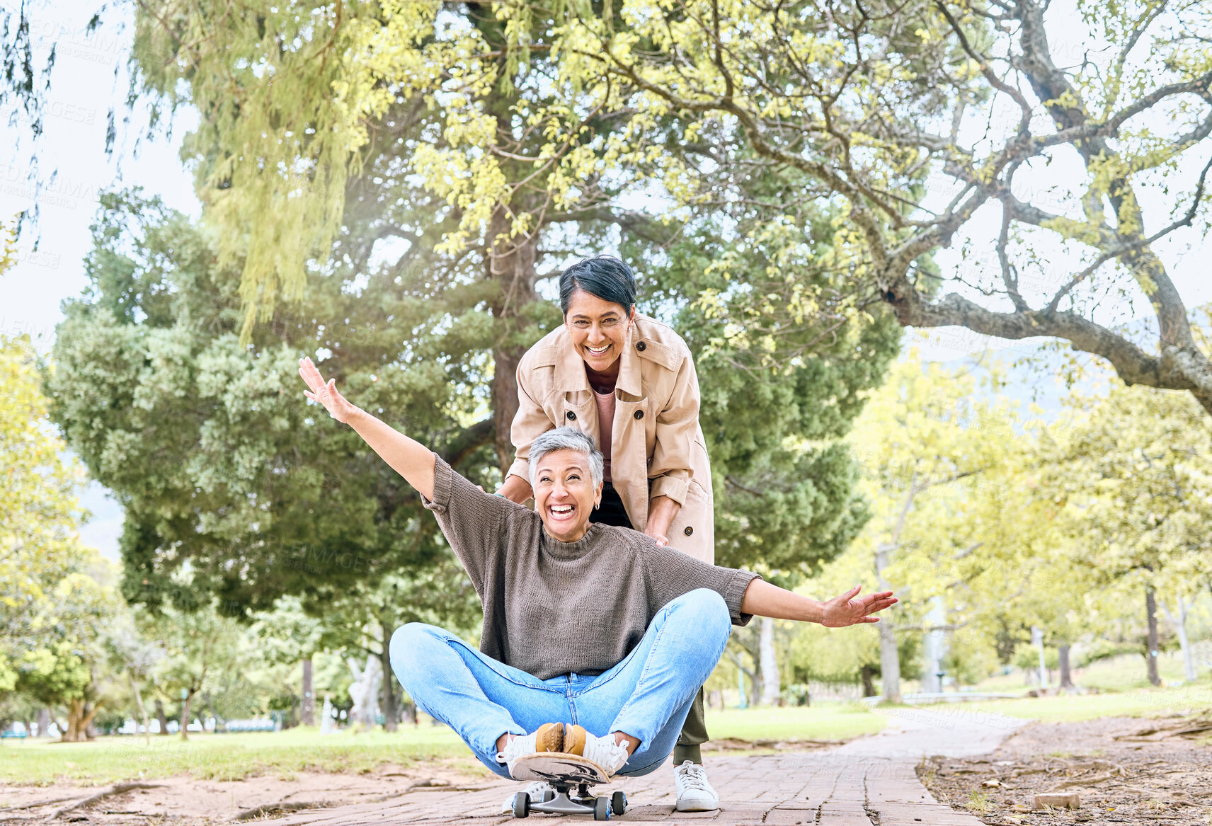 Buy stock photo Skateboard, portrait and senior friends in park for goofy, silly and comic outdoor fun together. Funny retirement women in nature with excited and happy smile for bonding leisure in Mexico.

