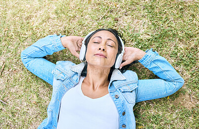 Buy stock photo Music, headphones and woman relax in a park, peace and zen from above, content and calm. Podcast, earphones and girl resting while listening to audio for wellness, stress free and chilling on grass
