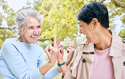 Buy stock photo Elderly, women and middle finger at the park for fun, humor and silly while laughing together. Mature, friends and females with hand, emoji and gesture, playful and happy, smile and bonding in nature