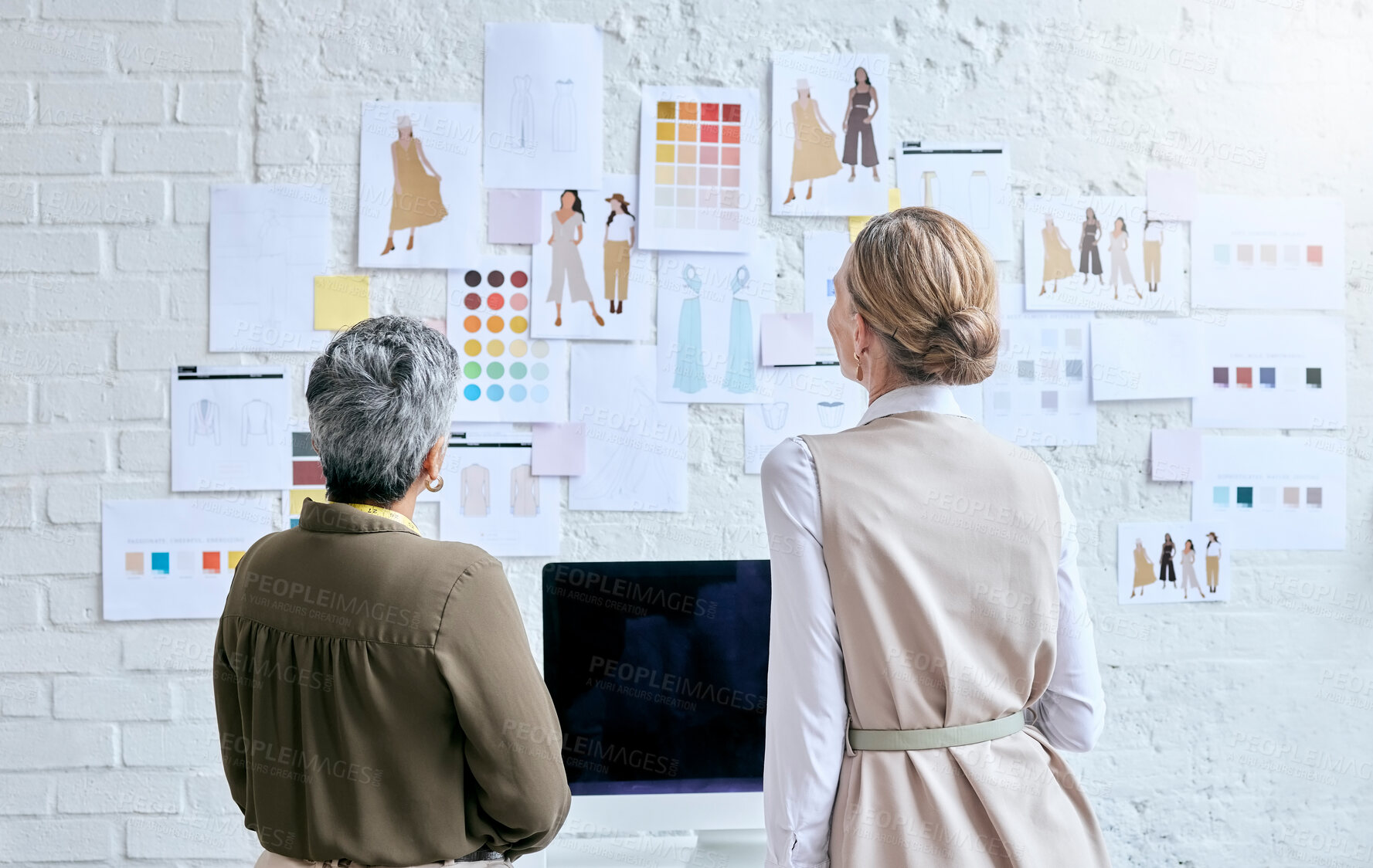 Buy stock photo Fashion, designer teamwork and back of women in workshop looking at designs on wall. Collaboration, small business and senior female tailors in boutique planning and discussing color choice or sketch