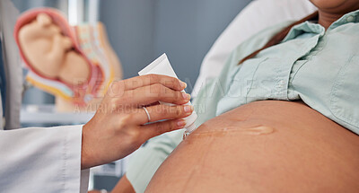 Buy stock photo Hand, stomach or pregnant with a doctor in hospital to apply gel to the skin of a woman during an appointment or checkup. Mother, health and pregnancy with the belly of a female parent in a clinic