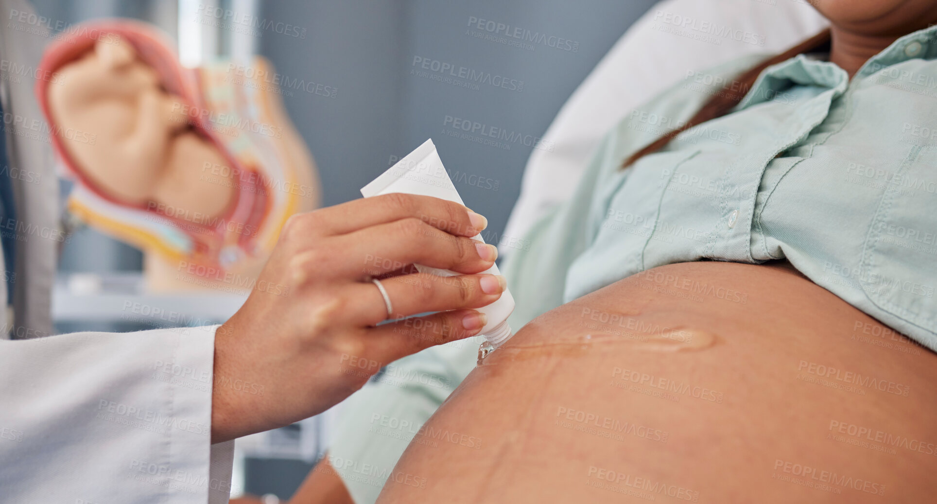 Buy stock photo Hand, stomach or pregnant with a doctor in hospital to apply gel to the skin of a woman during an appointment or checkup. Mother, health and pregnancy with the belly of a female parent in a clinic