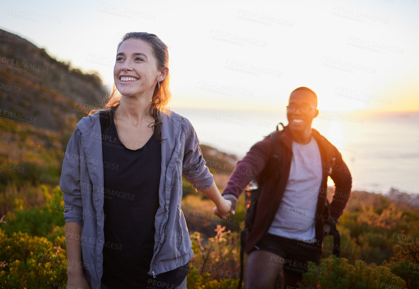 Buy stock photo Hiking, fitness and interracial couple exercise in sunset on a mountain as a morning workout in nature. Happy people, man and woman in a relationship training for health and wellness together