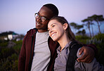 Happy couple, relax and love in an interracial relationship during sunset in the evening or night outdoors in nature. Adventure, travel and people hugging outdoors on after hiking a mountain