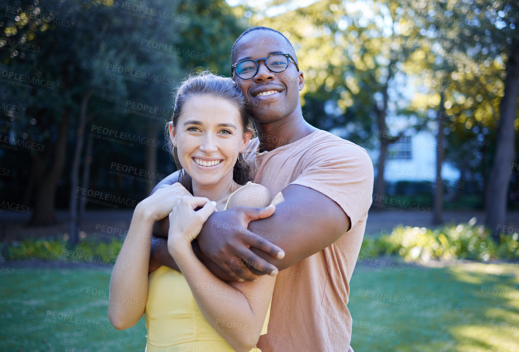 Buy stock photo Couple in portrait, date in park with hug and outdoor in nature, love and commitment with interracial relationship. Trust, support and happy people, black man and woman smile on face with fresh air