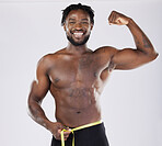 Muscular black man, tape measure and flexing in fitness for weight loss or dieting isolated on a grey background. Portrait of happy sporty male with smile for healthy lifestyle, fit body or muscle