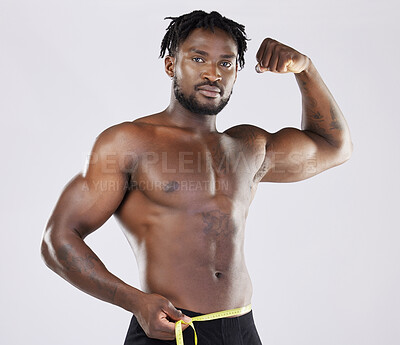 Buy stock photo Muscular black man, tape measure and isolated flexing on a grey background for fitness, weight loss or dieting. Portrait of African American male muscle flex, healthy body or empowerment