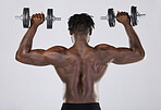 Fitness, exercise and training of strong black man with dumbells in studio. Body or back of bodybuilder person doing workout to train with weights for power, health and wellness or growth motivation