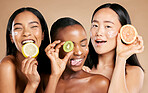 Face, fruit and women in portrait with cream for facial care, beauty and natural cosmetics isolated on studio background. Sunscreen, vegan and different skin with skincare, moisturizer and playful