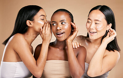 Buy stock photo Beauty secret, skincare cream and diversity women friends whisper about inclusion advertising in studio. Asian and black people talk about wow skin glow, spa facial and face with dermatology product
