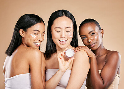 Buy stock photo Woman, skincare and face cream product in studio for wellness, skin and grooming on brown background. Facial, mask and friends relax for beauty, sunscreen and lotion, luxury and pamper while isolated