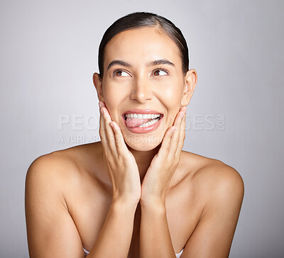 Buy stock photo Face, beauty and tongue with a model woman in studio, thinking about skincare on a gray background. Idea, facial and playful with an attractive young female posing to promote natural skin treatment