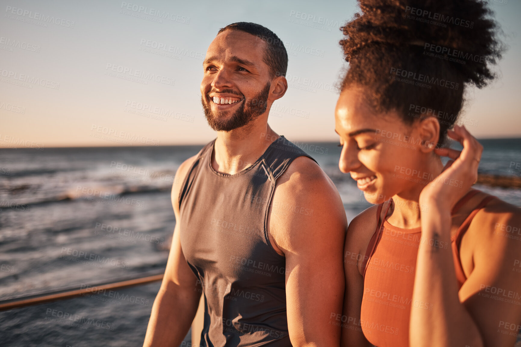 Buy stock photo Black couple, fitness and walking at the beach in conversation or talk together with smile for the outdoors. Happy man and woman enjoying fun sunset walk smiling for holiday break by the ocean coast