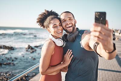 Buy stock photo Fitness, couple and phone in beach selfie with smile for running, exercise or workout in the outdoors. Happy man and woman smiling in happiness looking at smartphone for photo after run by the ocean